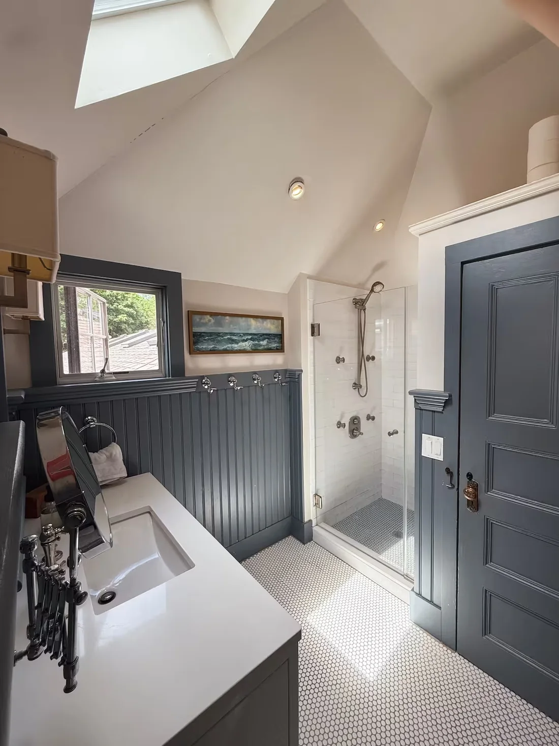 Bright full bathroom at Ptown Perch with a skylight, glass walk-in shower, vanity and penny-tile floor