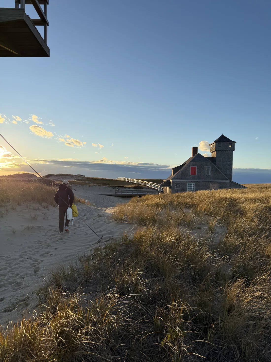 A dune trail leading toward a historic Provincetown dune shack at sunset