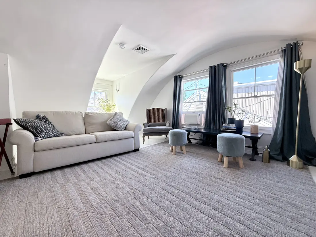 Ptown Perch living room with sleeper sofa, sitting area and Commercial Street windows