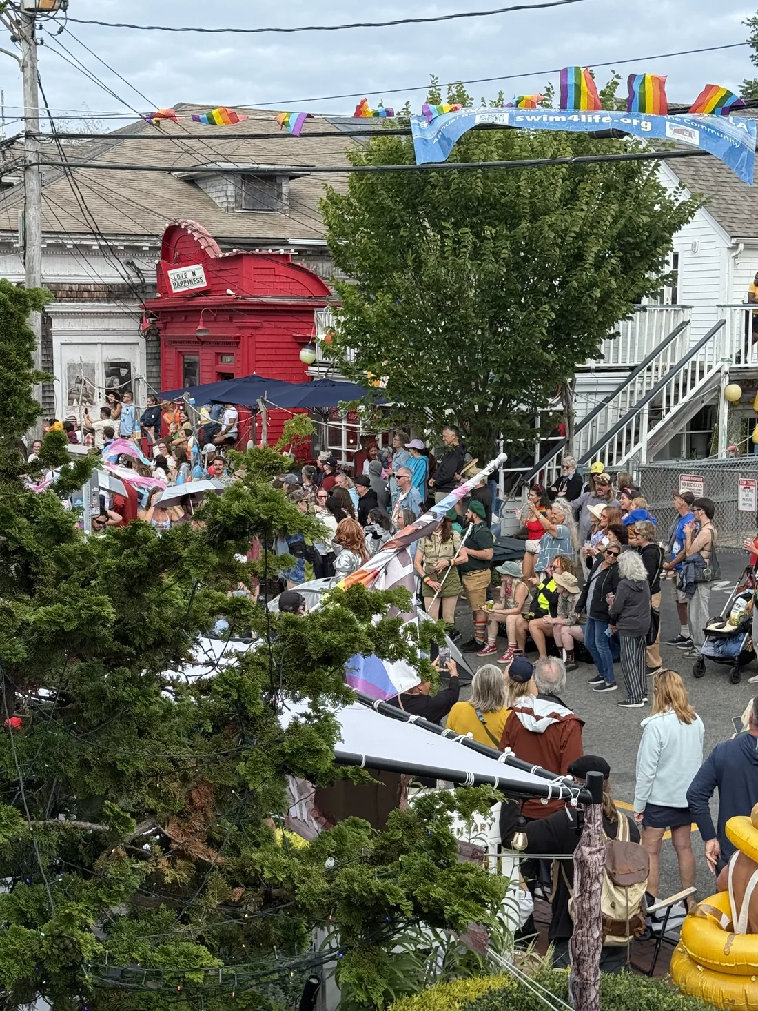 Crowds and performers during a Commercial Street parade in Provincetown