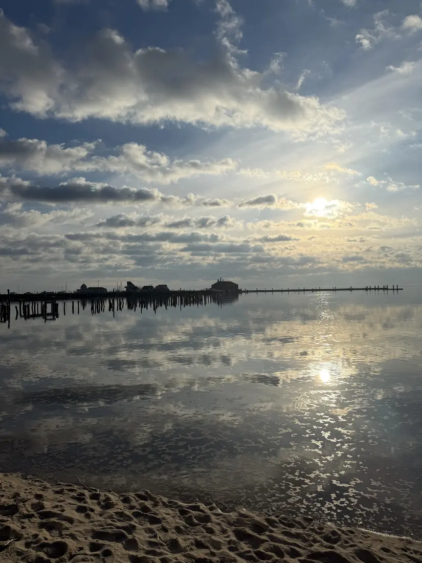Sunlight reflecting across calm Provincetown Harbor near the pier