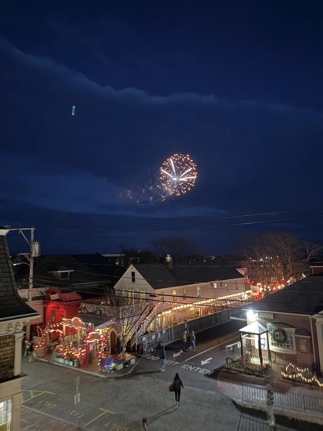 Commercial Street at night with Provincetown lights and a Ferris wheel in the distance